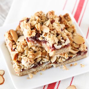 Gluten Free Vegan Raspberry Almond Crumb Bars. Layers of crumb topping, sweet raspberry jam and toasted almonds. The perfect bite!